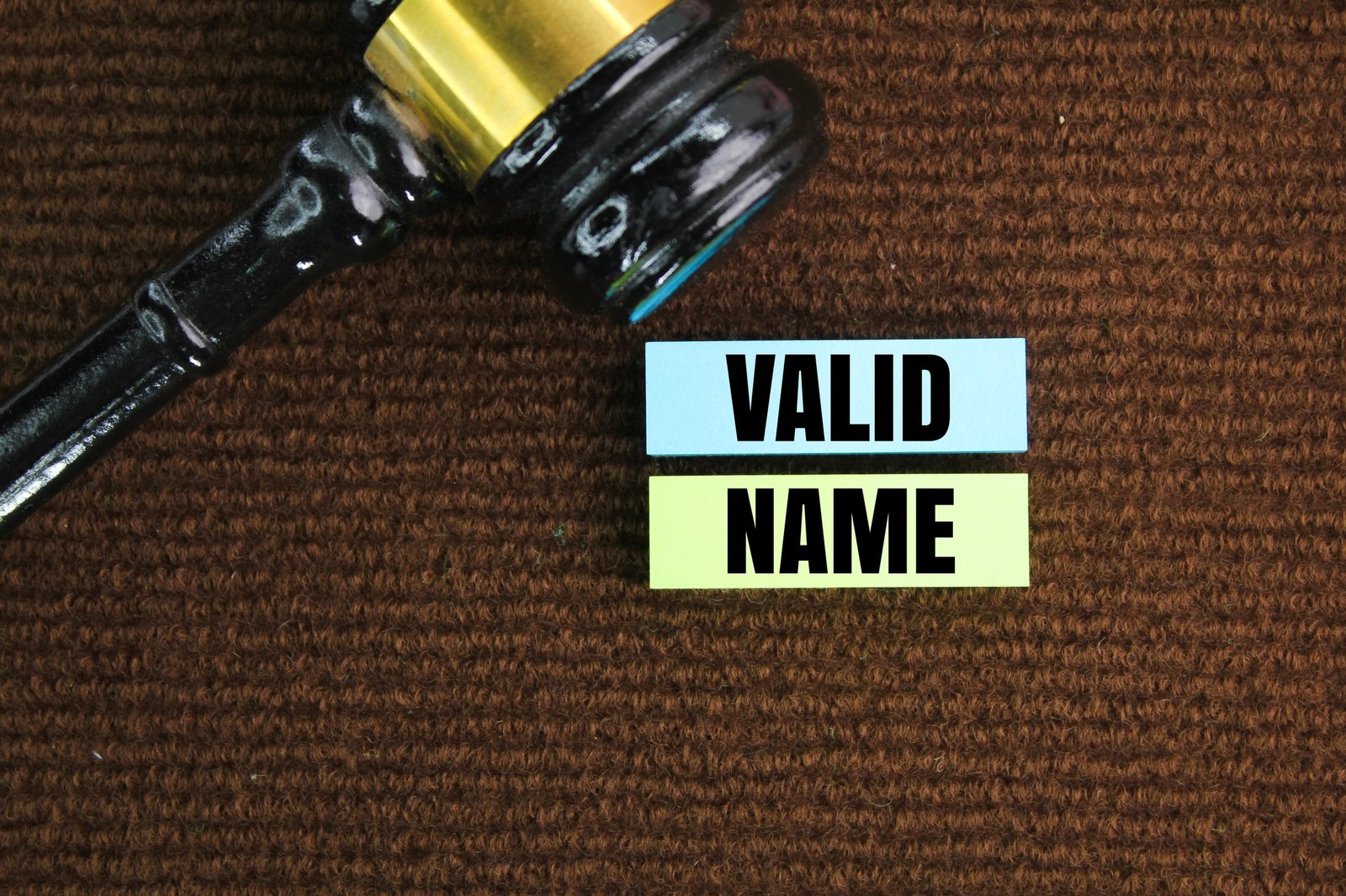 judge's hammer and colored paper with the word valid name.